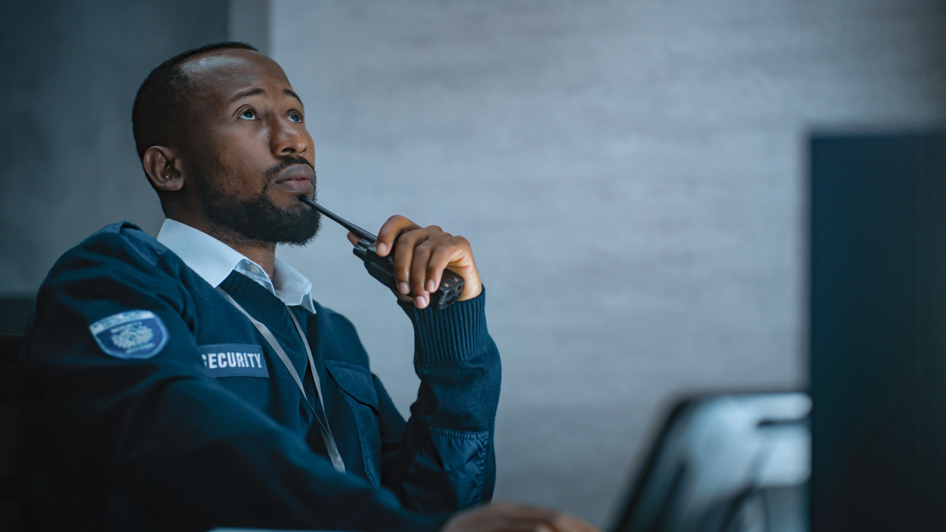 African American security officer works in monitoring center during night shift